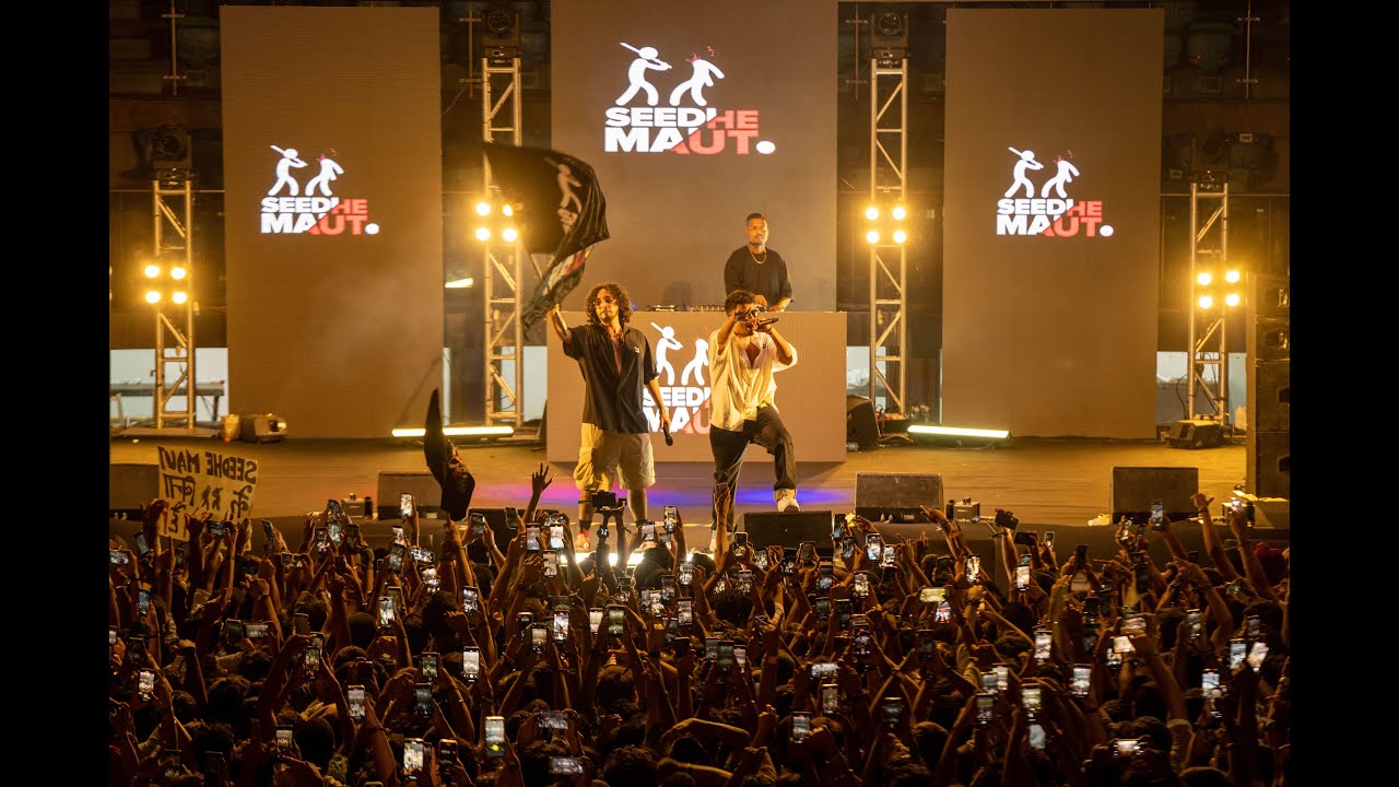 Two artists rapping under spotlights